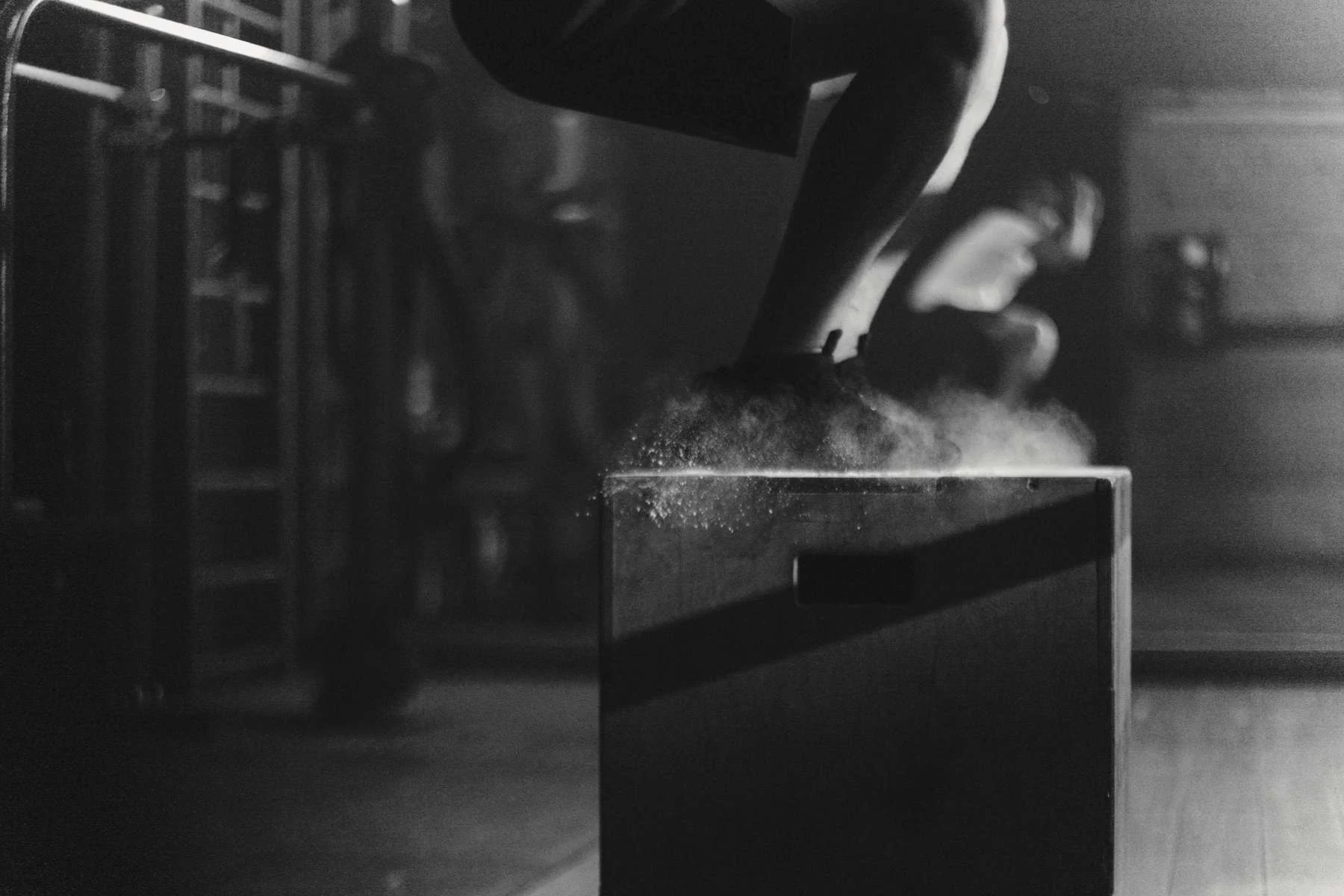 Atleta saltando sobre un cajón en un gimnasio